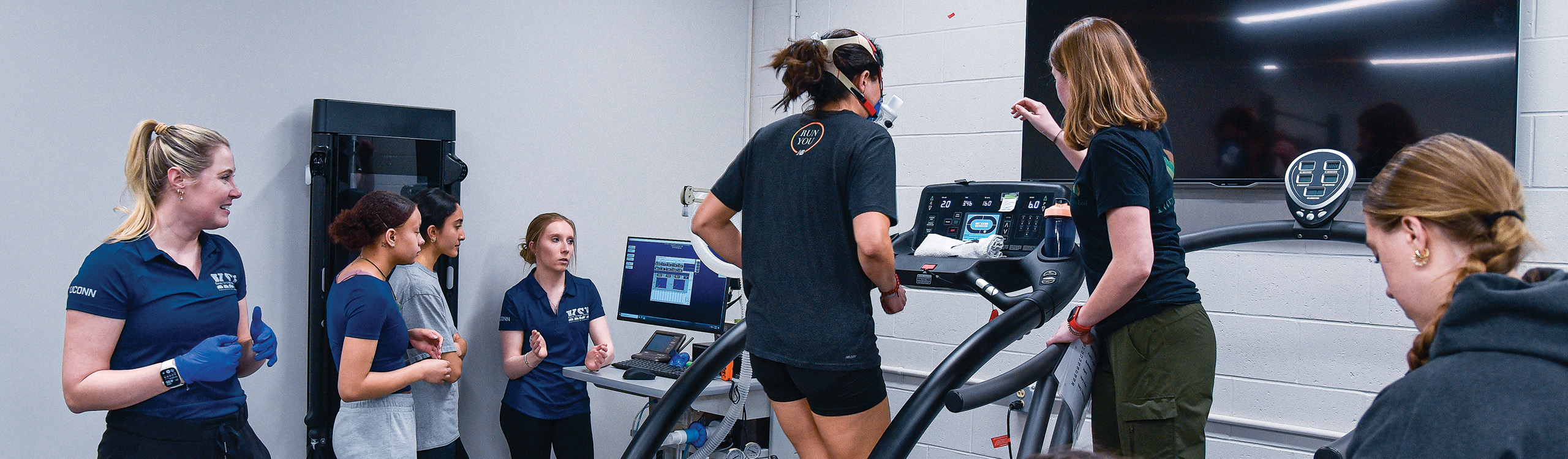 class gathered around runner on treadmill