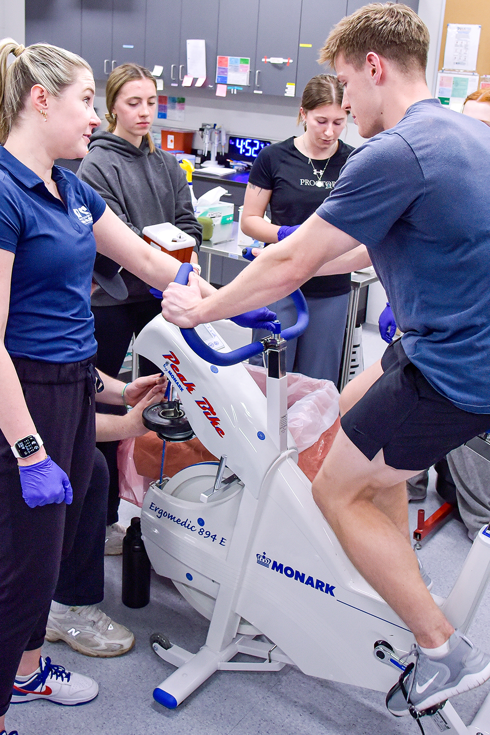 students studying a rider on an exercise bike